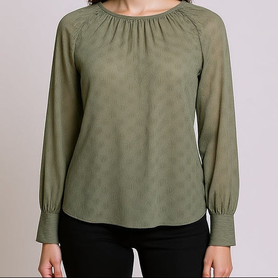 Woman wearing a Delilah Sage Blouse against a plain background