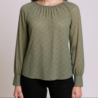 Woman wearing a Delilah Sage Blouse against a plain background