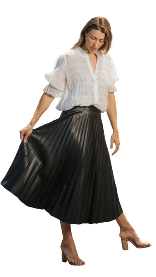 Woman wearing a white blouse and black pleated skirt on a white background